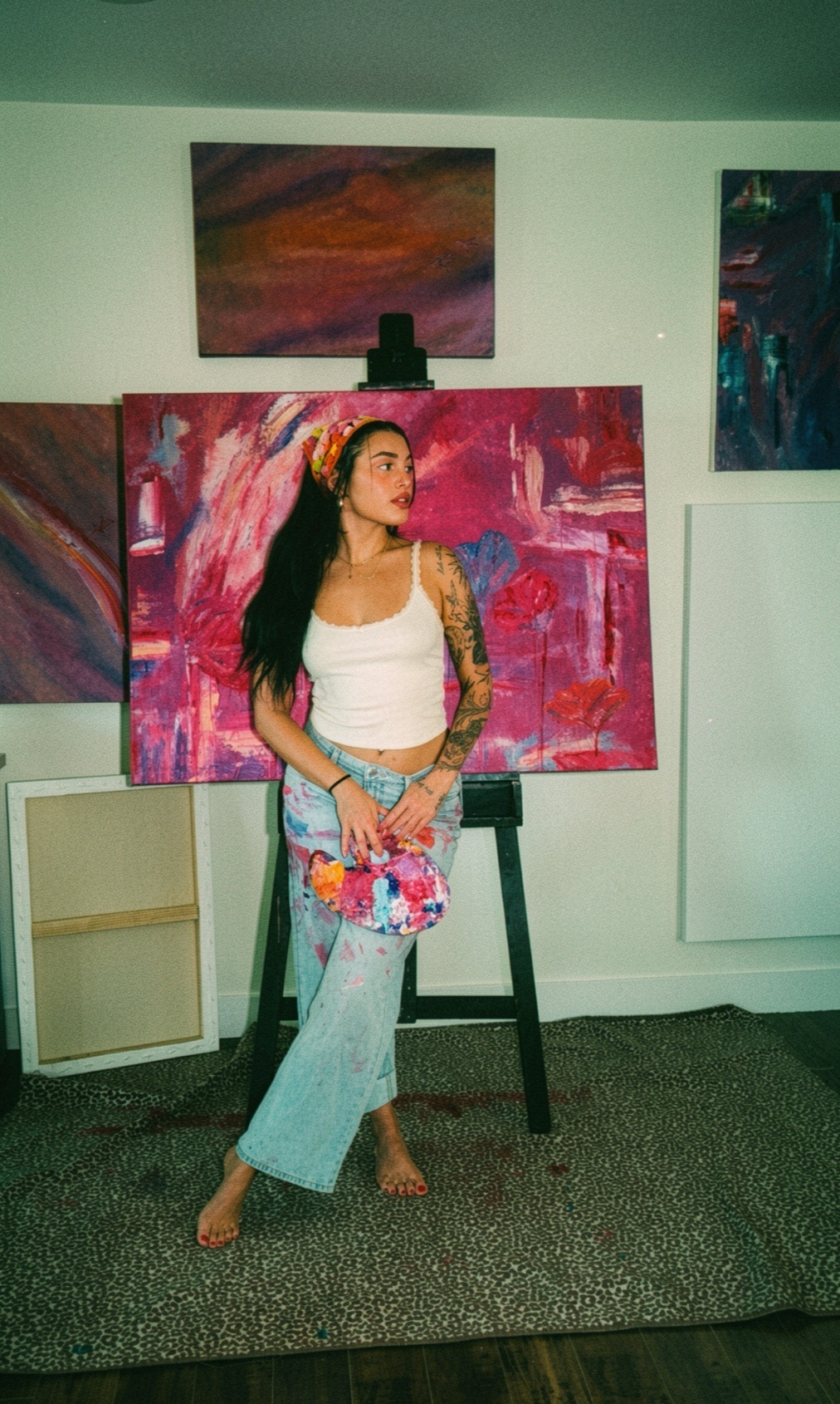Huntress pausing at the easel between brushstrokes
